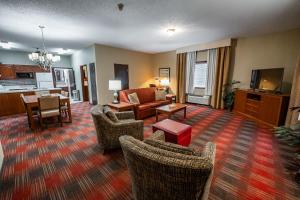 a living room with a couch and chairs and a table at Christopher Inn and Suites in Chillicothe