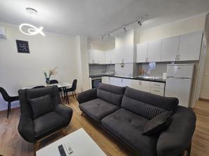 a living room with a couch and a kitchen at New Bazar-Central Apartment 1 with balcony in Tirana
