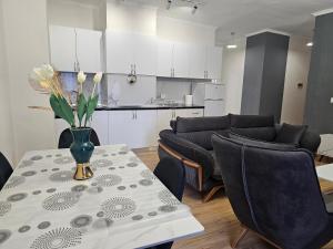 a living room with a table with a vase of flowers on it at New Bazar-Central Apartment 1 with balcony in Tirana +2 photos