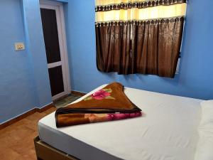 a bed with a brown blanket on top of it at Valley Villa 2BHK in Kodaikānāl