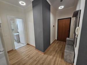 an empty room with a hallway with a door and wooden floor at New Bazar-Central Apartment 1 with balcony in Tirana