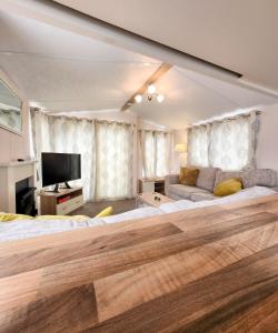 a large bedroom with a large bed and a couch at Serene Stay: Beautiful 2Bed Lodge in Kelsall in Kelsall