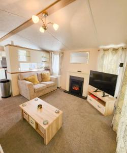 un soggiorno con divano, TV e camino di Serene Stay: Beautiful 2Bed Lodge in Kelsall a Kelsall