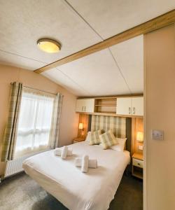 una camera da letto con un grande letto bianco e una finestra di Serene Stay: Beautiful 2Bed Lodge in Kelsall a Kelsall