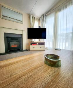a living room with a fireplace and a dog bowl on the floor at Serene Stay: Beautiful 2Bed Lodge in Kelsall in Kelsall