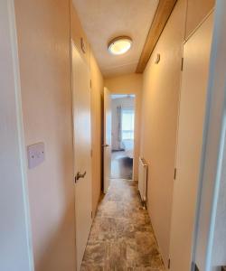 un corridoio che conduce a una camera con porta e corridoio di Serene Stay: Beautiful 2Bed Lodge in Kelsall a Kelsall