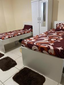 two beds in a room with rugs on the floor at برج المحطة in Sharjah