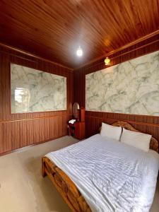 een slaapkamer met een groot bed en een stenen muur bij Dong Quan villa in Da Lat