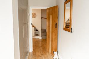 a cat sitting in the hallway of a house at Cosy 2 bed cottage in charming village of Christleton - For up to 5 in Christleton +27 photos