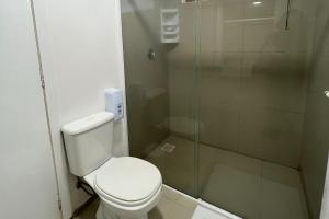 a bathroom with a toilet and a glass shower at Pousada Bernúncia in Penha