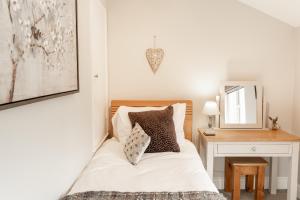 1 dormitorio con cama y mesa con espejo en Cosy 2 bed cottage in charming village of Christleton - For up to 5 en Christleton