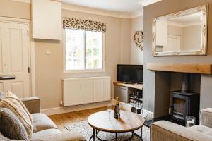 uma sala de estar com lareira e televisão em Cosy 2 bed cottage in charming village of Christleton - For up to 5 em Christleton