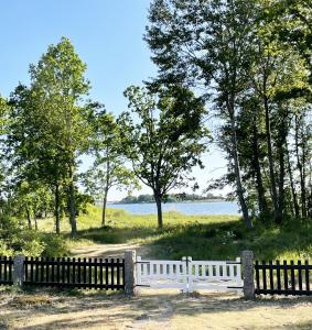 una cerca blanca frente a un cuerpo de agua en Holiday home by the sea with fantastic views en Ronneby