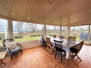 a screened in porch with a table and chairs at Holiday home by the sea with fantastic views in Ronneby