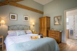 a bedroom with a bed and a bathroom with a sink at Thyme Lodge Drefach Felindre in Felindre