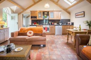 a living room with a couch and a kitchen at Thyme Lodge Drefach Felindre in Felindre