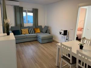 ein Wohnzimmer mit einem Sofa und einem Tisch in der Unterkunft Apartamento Barbados in Fuengirola