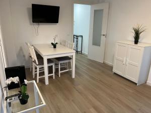 - un salon avec une table et des chaises blanches dans l'établissement Apartamento Barbados, à Fuengirola