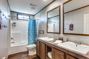 a bathroom with a sink and a toilet and a mirror at Sunset Cove Lakefront Rental with Private Dock! in Blanchard +24 photos