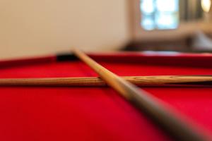 two cue sticks on top of a pool table at Cozy 2BR Retreat | Prime Cardiff Location in Cardiff