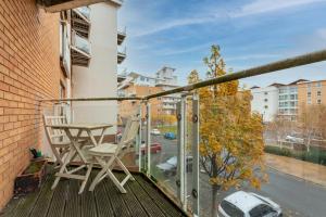 a balcony with a table and a chair on it at Cozy 2BR Retreat | Prime Cardiff Location in Cardiff