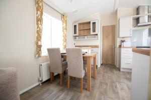 a kitchen with a dining room table and chairs at Skegness Holidays in Skegness