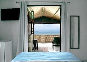 a bedroom with a view of the ocean through a door at Hotel Pousada Estacao Do Sol Natal in Natal