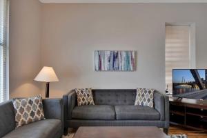 a living room with a couch and a tv at Breathtaking Unit in Shaw - 4 Queen beds 1E in Tower Grove