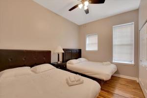 a bedroom with two beds and a ceiling fan at Breathtaking Unit in Shaw - 4 Queen beds 1E in Tower Grove