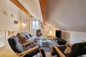 a living room with a couch and chairs and a tv at le bien-être de la nature in Séchilienne