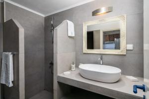 a bathroom with a white sink and a mirror at Skinopi Beach Guesthouse in Schinopi +15 photos