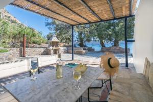 a table with glasses of wine on a patio at Skinopi Beach Guesthouse in Schinopi