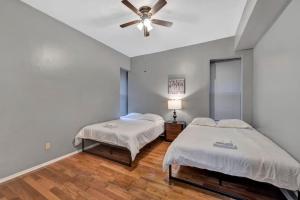 two beds in a room with a ceiling fan at Breathtaking Unit in Shaw - 4 Queen beds 1W in Tower Grove