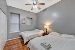 a bedroom with two beds and a ceiling fan at Breathtaking Unit in Shaw - 4 Queen beds 1W in Tower Grove