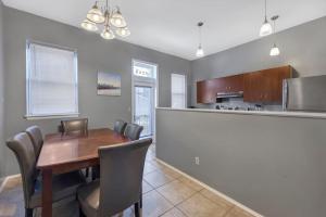 a kitchen and dining room with a wooden table and chairs at Breathtaking Unit in Shaw - 4 Queen beds 1W in Tower Grove
