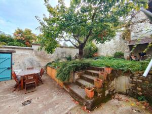 une terrasse avec une table, un arbre et des escaliers. dans l'établissement Home - Saint Pèlerin - Séjour à Auxerre, à Auxerre