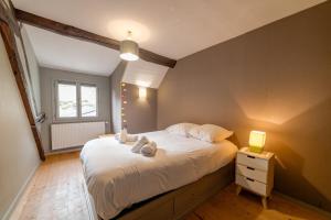 a bedroom with a bed with white sheets and a window at Home St Pèlerin in Auxerre