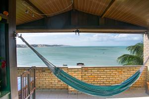 een hangmat op een veranda met uitzicht op de oceaan bij Hotel Pousada Estacao Do Sol Natal in Natal
