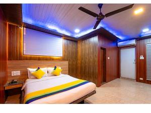 1 dormitorio con 1 cama grande y ventilador de techo en New Sun n S Resort Matheran, en Matheran