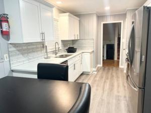 a kitchen with white cabinets and a stainless steel refrigerator at Full Suite with Hot Tub Wifi Room 4 in Atlanta