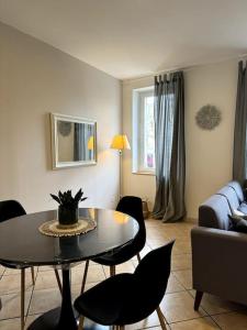 ein Wohnzimmer mit einem Tisch, Stühlen und einem Sofa in der Unterkunft Appartement central à Castelnaudary in Castelnaudary