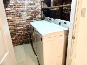 a washer and dryer in a room with a brick wall at Full Suite with Hot Tub Wifi Room 4 in Atlanta