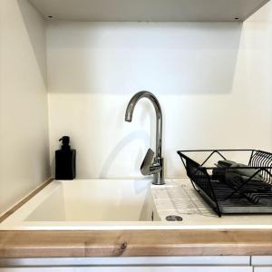 eine Küchentheke mit einer Spüle mit einem Wasserhahn in der Unterkunft Appartement central à Castelnaudary in Castelnaudary