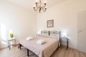 a bedroom with a bed and a chandelier at Oltretorrente Ospedale Apartment in Parma