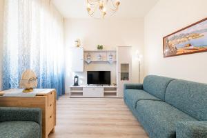 a living room with a blue couch and a tv at Oltretorrente Ospedale Apartment in Parma
