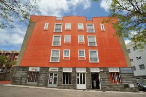 duży pomarańczowy budynek z białymi oknami na ulicy w obiekcie One bedroom appartement with terrace and wifi at San Cristobal de La Laguna w mieście La Laguna