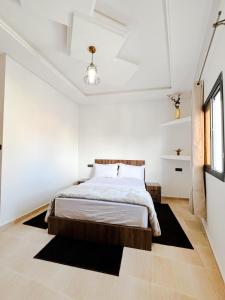 una camera bianca con un letto di Hotel Ahmed Ali a Dakhla