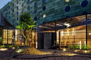 a building with a palm tree in front of it at Hotel Unique in Sao Paulo