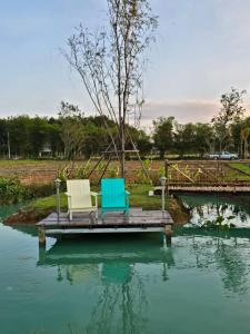 two chairs sitting on a dock in the water at ฟาร์มผัก Thank you in Ban Kom