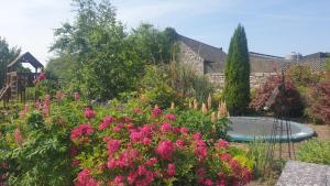 um jardim com flores cor-de-rosa e um banho de pássaros em Grove Cottage at The Lodge em Tullow